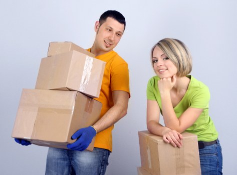 Movers carrying furniture through a residential building in Barnes