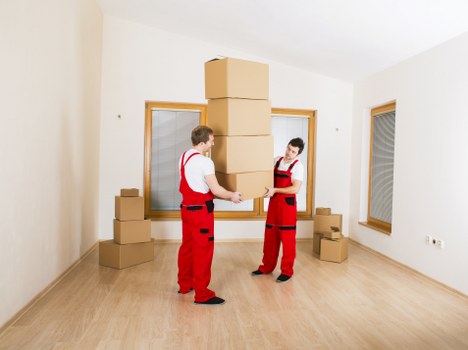 Removal specialists preparing furniture for transport in Barnes